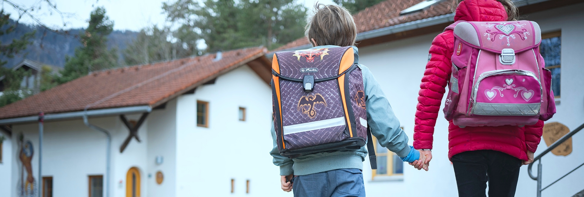 zwei Kinder mit Schultasche