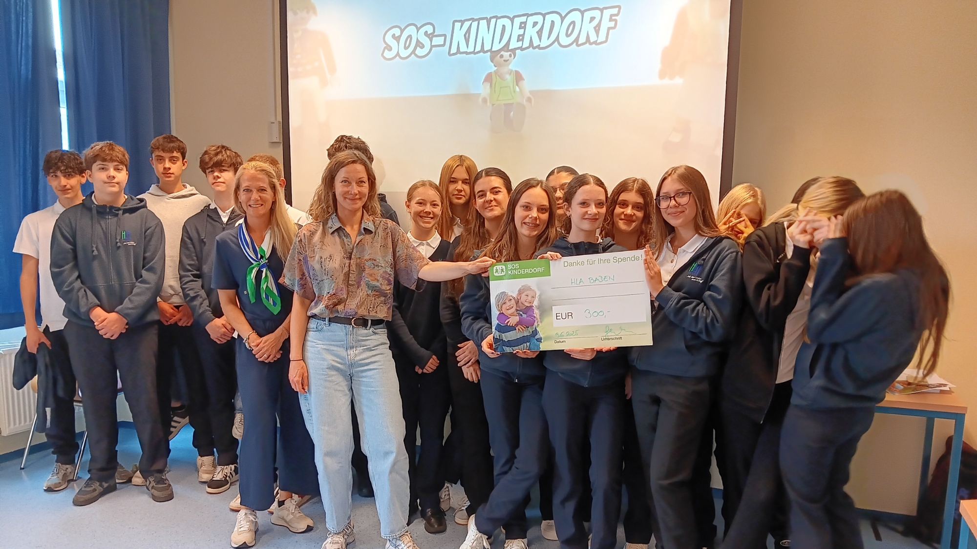 Die Schüler*innen der 1MMA mit einem großen Scheck für SOS-Kinderdorf