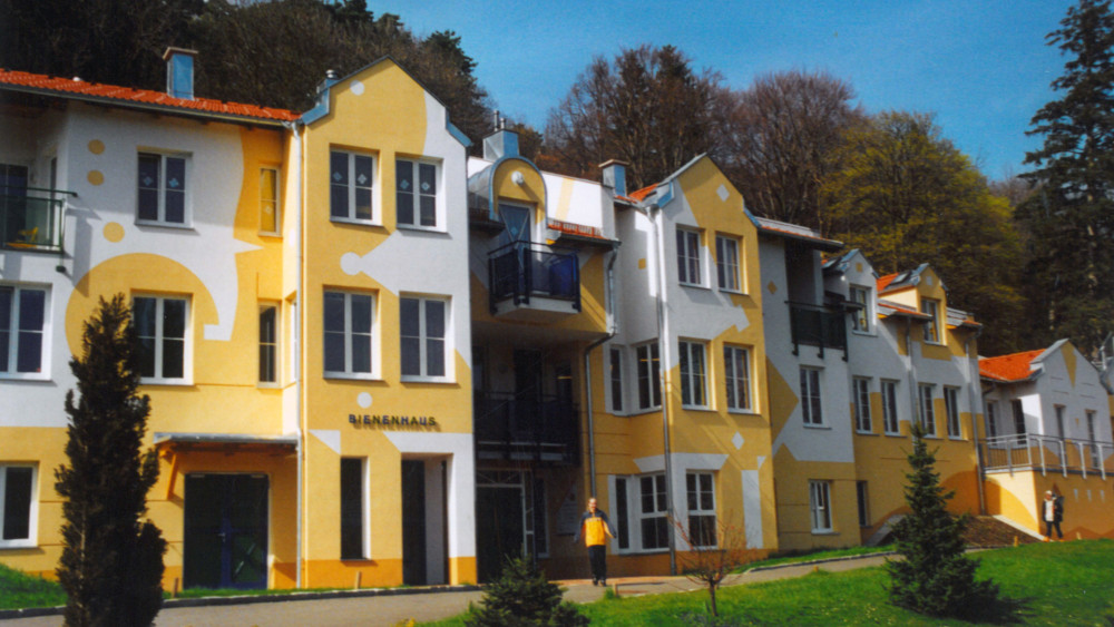 Großes, gelb-weiß gestrichenes Haus mit der Aufschrift "Bienenhaus"