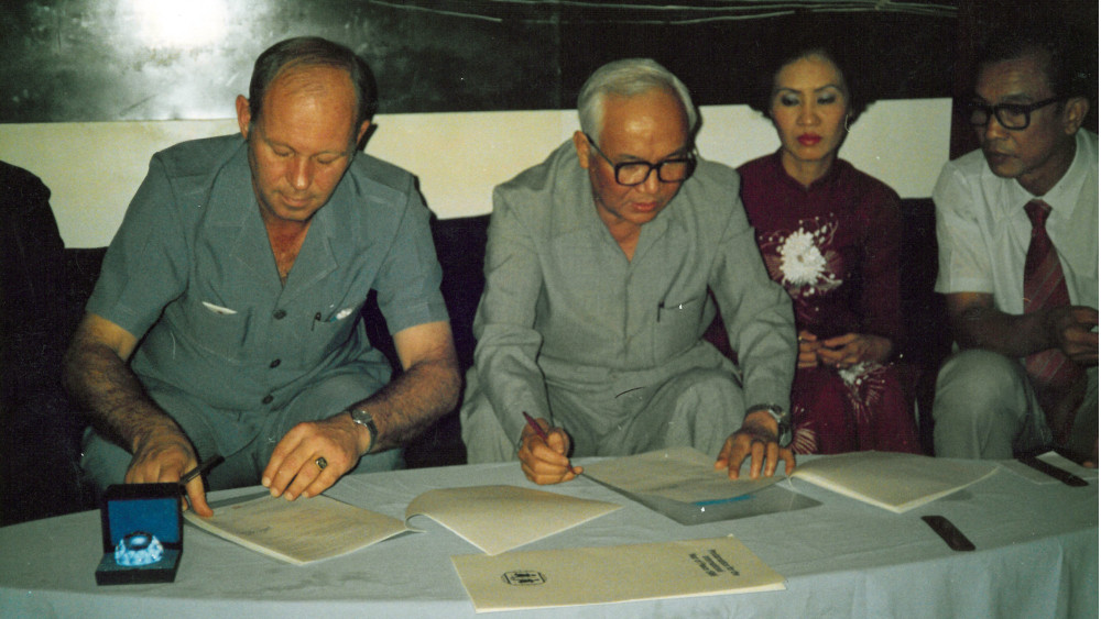 Helmut Kutin am Tisch mit vier weiteren Menschen und einigen Dokumenten