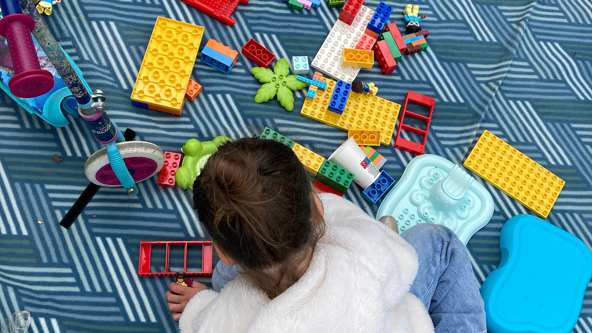 Kind spielt gemütlich auf Teppich
