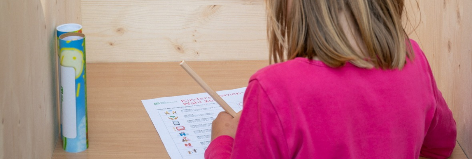 Ein Kind füllt einen Wahlzettel bei der Kinderstimmenwahl aus