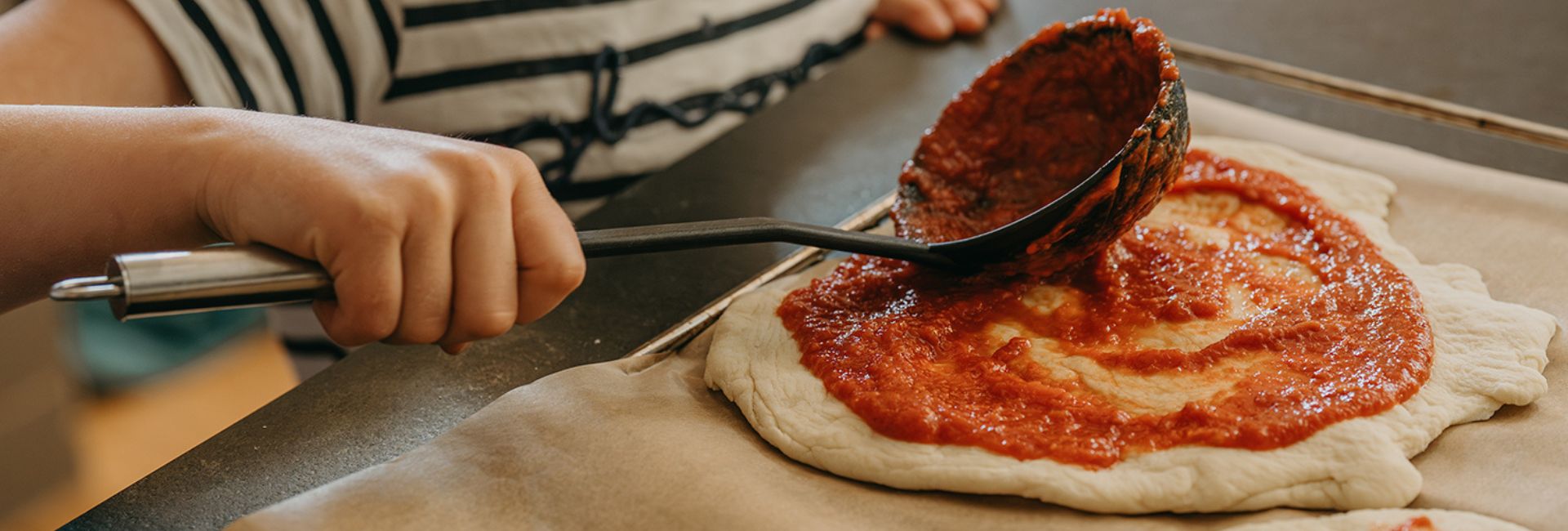 Ein Kind beim Pizza machen